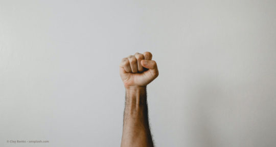 Ein Mann streckt die Faust nach oben © Clay Banks – unsplash.com