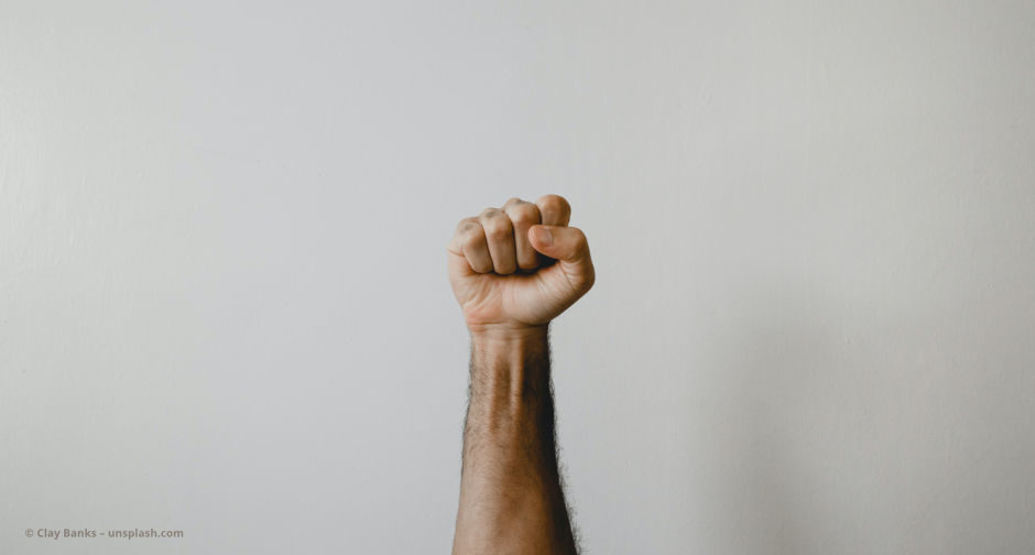 Ein Mann streckt die Faust nach oben © Clay Banks – unsplash.com