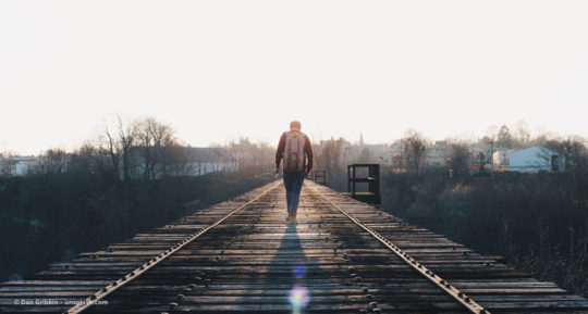 Man geht auf einer Bahn-Strecke vom Betrachter aus weg. © Dan Gribbin – unsplash.com