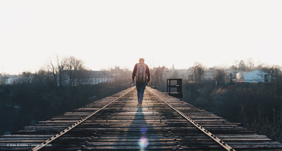 Man geht auf einer Bahn-Strecke vom Betrachter aus weg. © Dan Gribbin – unsplash.com